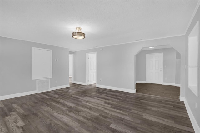 interior space featuring ornamental molding, dark hardwood / wood-style floors, and a textured ceiling