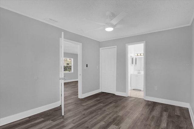 empty room with ornamental molding, dark hardwood / wood-style floors, and ceiling fan