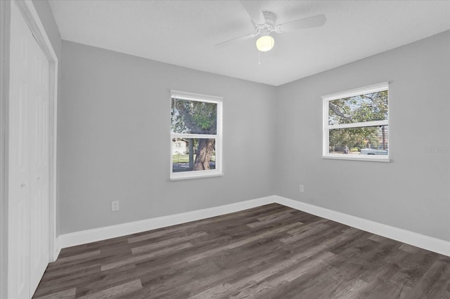 unfurnished room featuring dark wood-type flooring, plenty of natural light, and ceiling fan