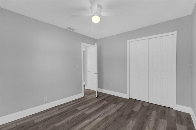 unfurnished bedroom with dark wood-type flooring, a closet, and ceiling fan