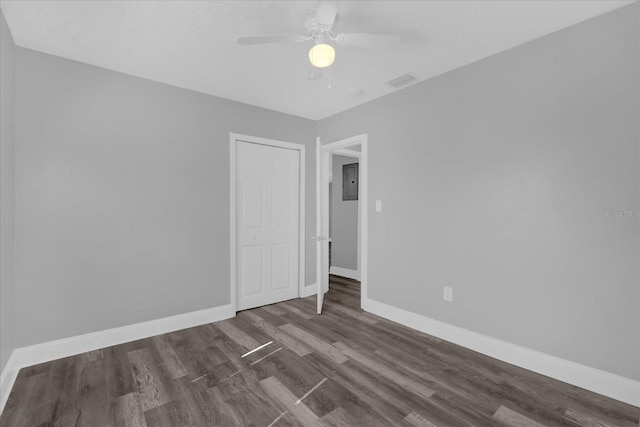 spare room featuring dark hardwood / wood-style flooring, electric panel, and ceiling fan