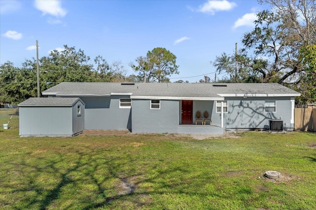 rear view of property with a yard, central AC, and a patio area