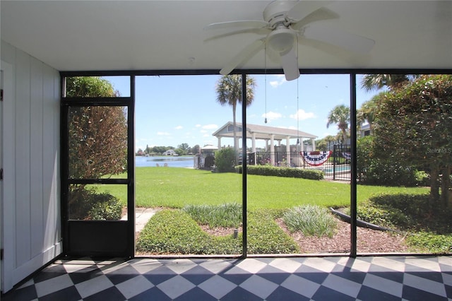 unfurnished sunroom featuring a water view, plenty of natural light, and ceiling fan