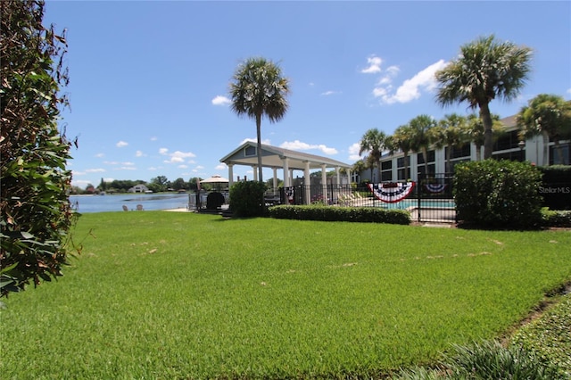 view of yard featuring a water view, a community pool, and a gazebo