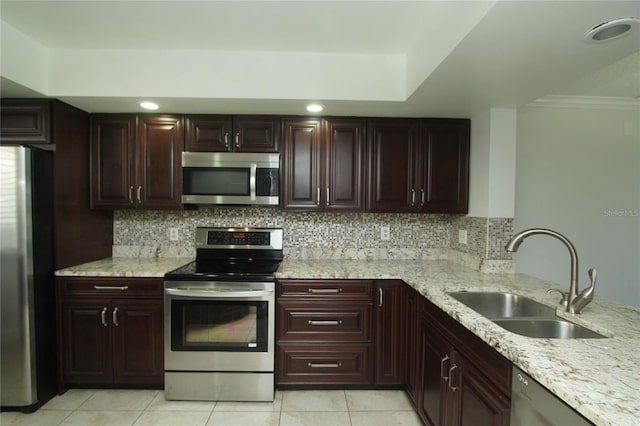 kitchen featuring tasteful backsplash, appliances with stainless steel finishes, sink, and light stone counters