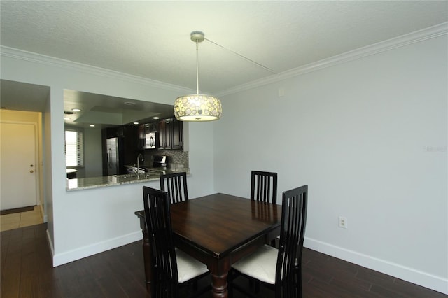 dining room with ornamental molding, dark hardwood / wood-style floors, and sink