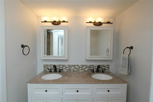 bathroom featuring vanity, decorative backsplash, and a textured ceiling