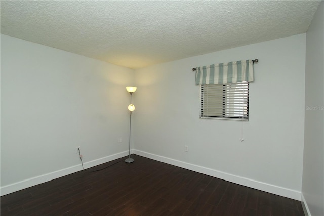 empty room featuring dark hardwood / wood-style floors and a textured ceiling