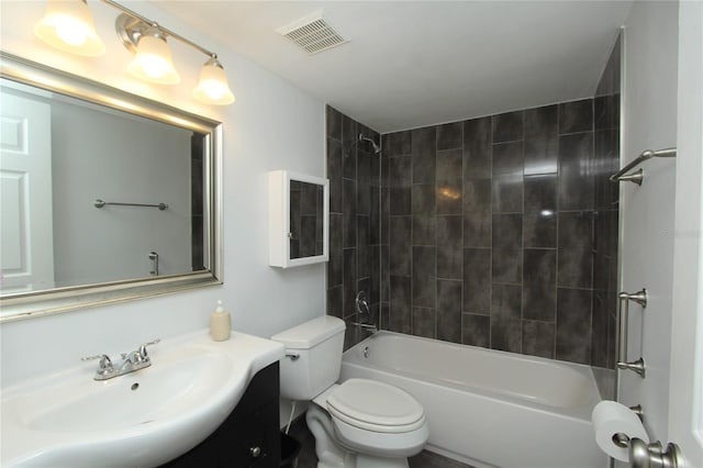 full bathroom with tiled shower / bath, vanity, and toilet