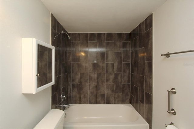 bathroom featuring tiled shower / bath combo and toilet