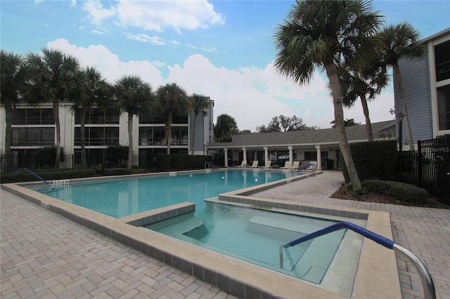 view of swimming pool with a hot tub and a patio