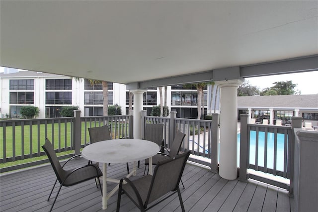 deck featuring a community pool and a yard