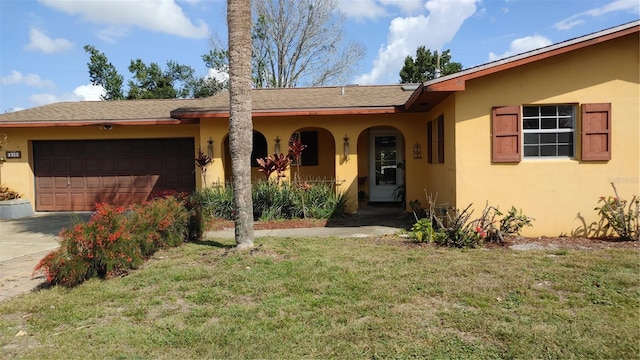 ranch-style house featuring a garage and a front lawn