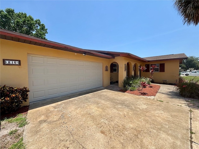 210 Dartmouth St, Deltona, FL 32725 - view of front of house with driveway, stucco siding, and an attached garage
