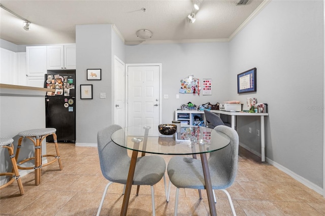 dining room with crown molding and rail lighting