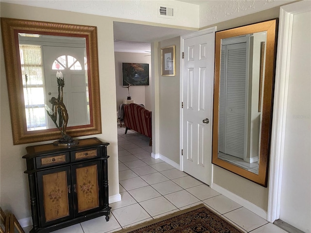 foyer featuring light tile patterned floors, visible vents, and baseboards