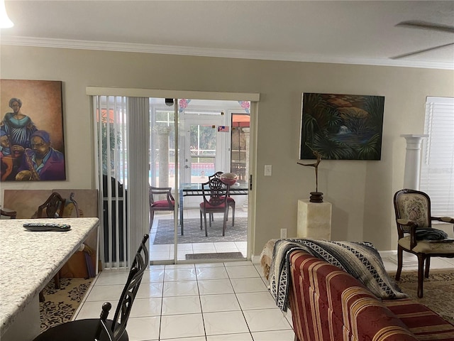 living room featuring light tile patterned floors, baseboards, and crown molding