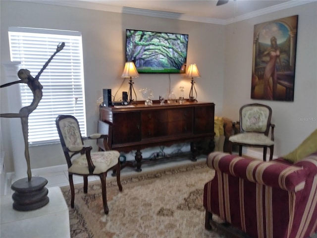 sitting room featuring tile patterned floors, baseboards, ceiling fan, and ornamental molding