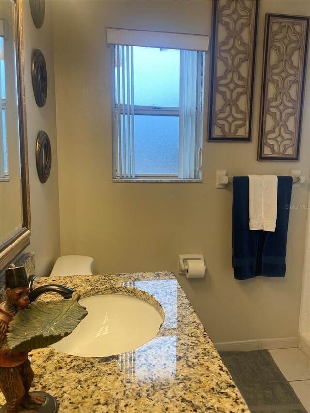 bathroom with baseboards, vanity, and tile patterned flooring