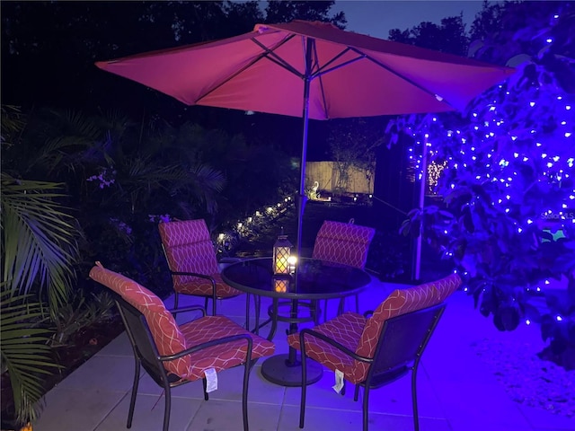 patio at night featuring outdoor dining space