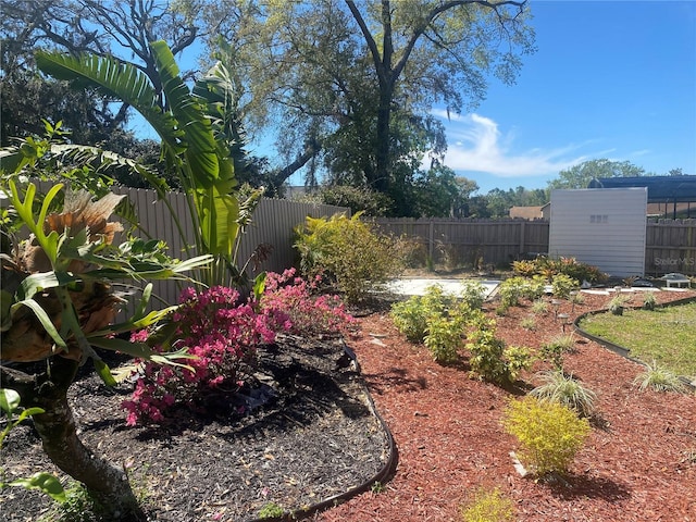 view of yard featuring an outbuilding, a storage unit, and a fenced backyard