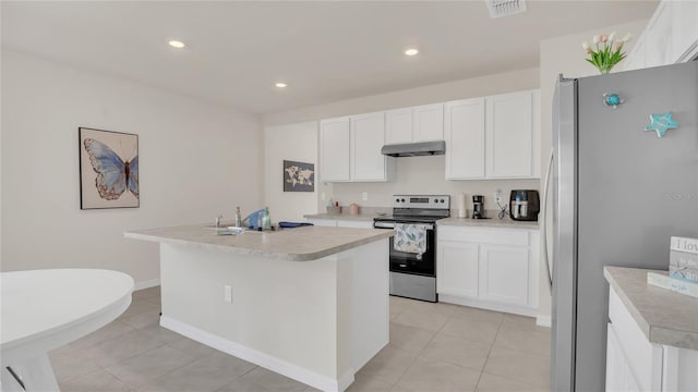 kitchen with stainless steel appliances, a kitchen island with sink, light tile patterned floors, and white cabinets