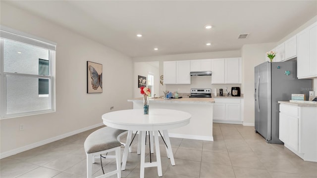 kitchen featuring appliances with stainless steel finishes, a wealth of natural light, and white cabinets