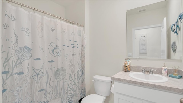 bathroom featuring vanity, toilet, and curtained shower