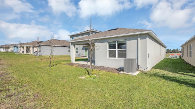 back of property with a lawn and central air condition unit