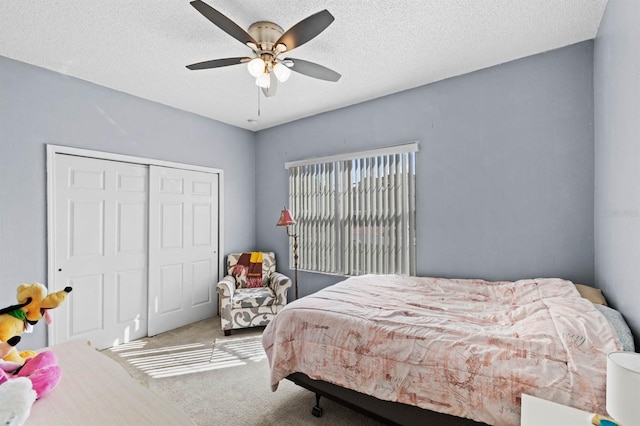 bedroom featuring ceiling fan, carpet floors, a closet, and a textured ceiling