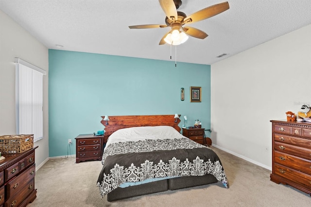 carpeted bedroom with ceiling fan and a textured ceiling