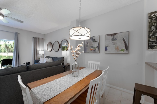 tiled dining space with ceiling fan and a textured ceiling