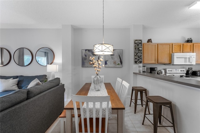 tiled dining space with a textured ceiling