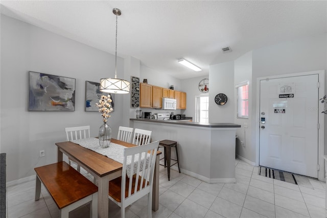 tiled dining space featuring a textured ceiling