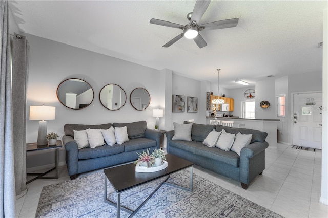 tiled living room featuring ceiling fan and a textured ceiling