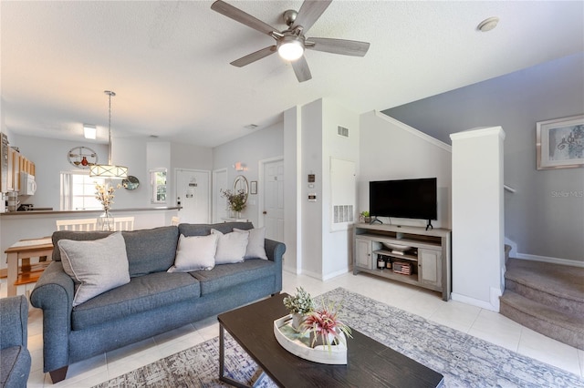 living room featuring ceiling fan, vaulted ceiling, a textured ceiling, and light tile patterned floors