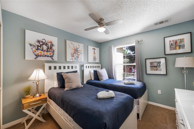 bedroom with ceiling fan, carpet floors, and a textured ceiling