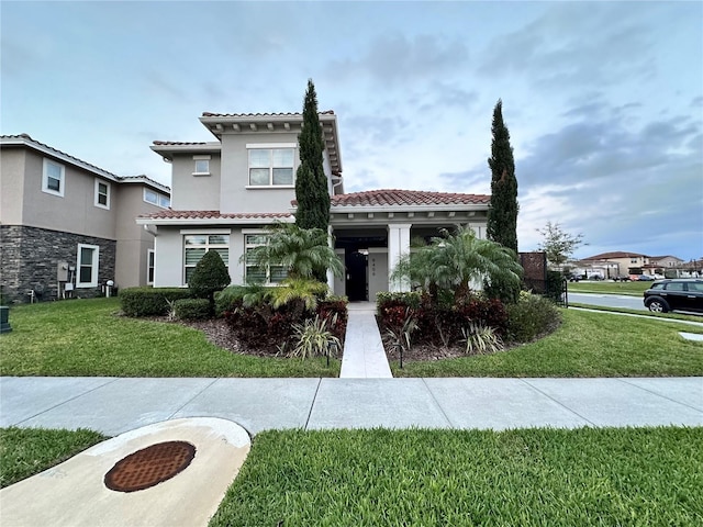 mediterranean / spanish-style house featuring central AC unit and a front lawn