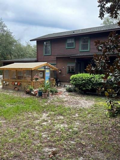 back of property featuring an outdoor structure