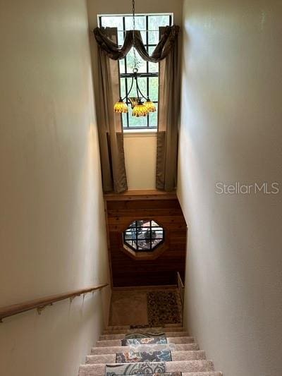 stairs featuring an inviting chandelier