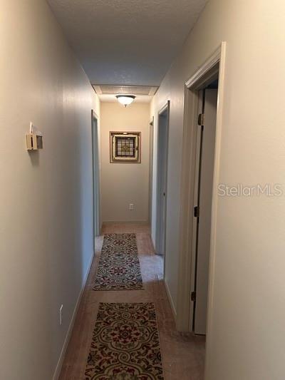 corridor featuring a textured ceiling