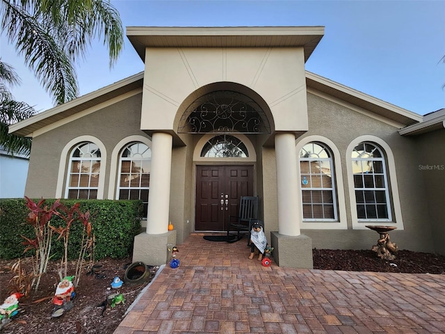 view of exterior entry with stucco siding