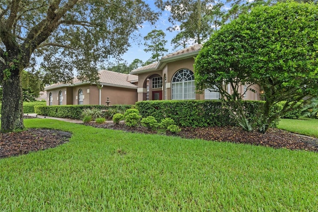 mediterranean / spanish home featuring a front lawn