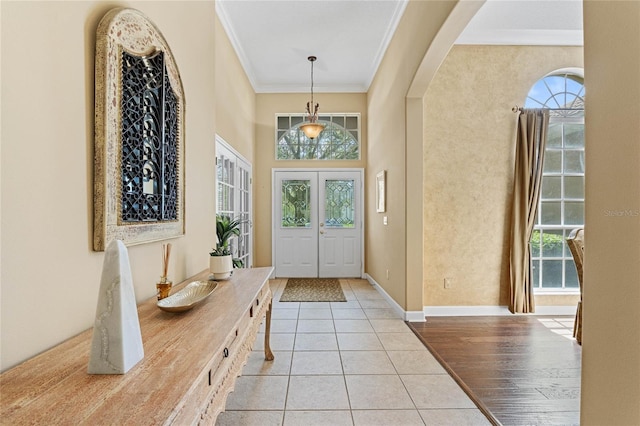 tiled entrance foyer with a towering ceiling and ornamental molding