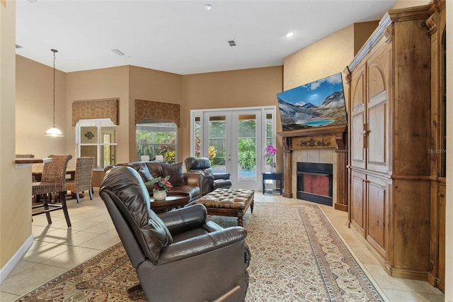 living room with light tile patterned flooring, a tile fireplace, and french doors