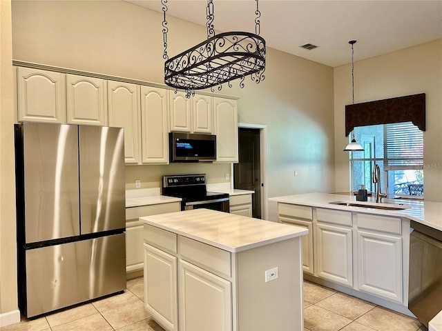 kitchen with a kitchen island, sink, white cabinets, hanging light fixtures, and stainless steel appliances