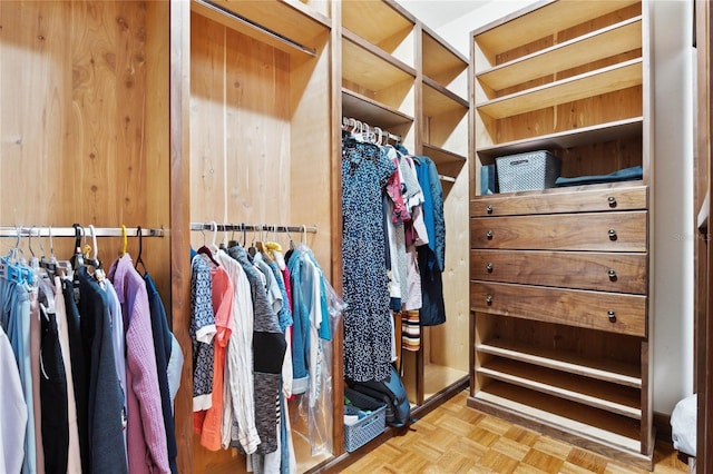 walk in closet with light parquet flooring