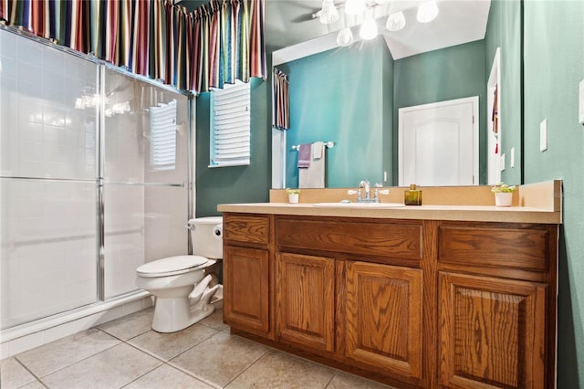 bathroom with tile patterned floors, toilet, a shower with shower door, vanity, and ceiling fan