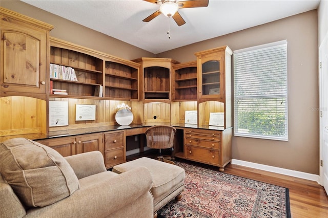 office featuring ceiling fan, built in desk, and hardwood / wood-style floors