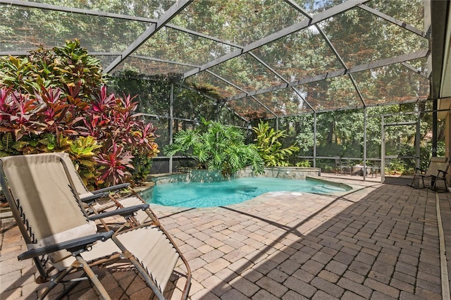 view of pool with glass enclosure and a patio